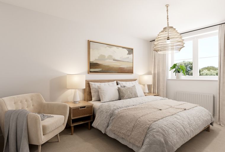 A bedroom with a bed, armchair, bedside tables, and a window.