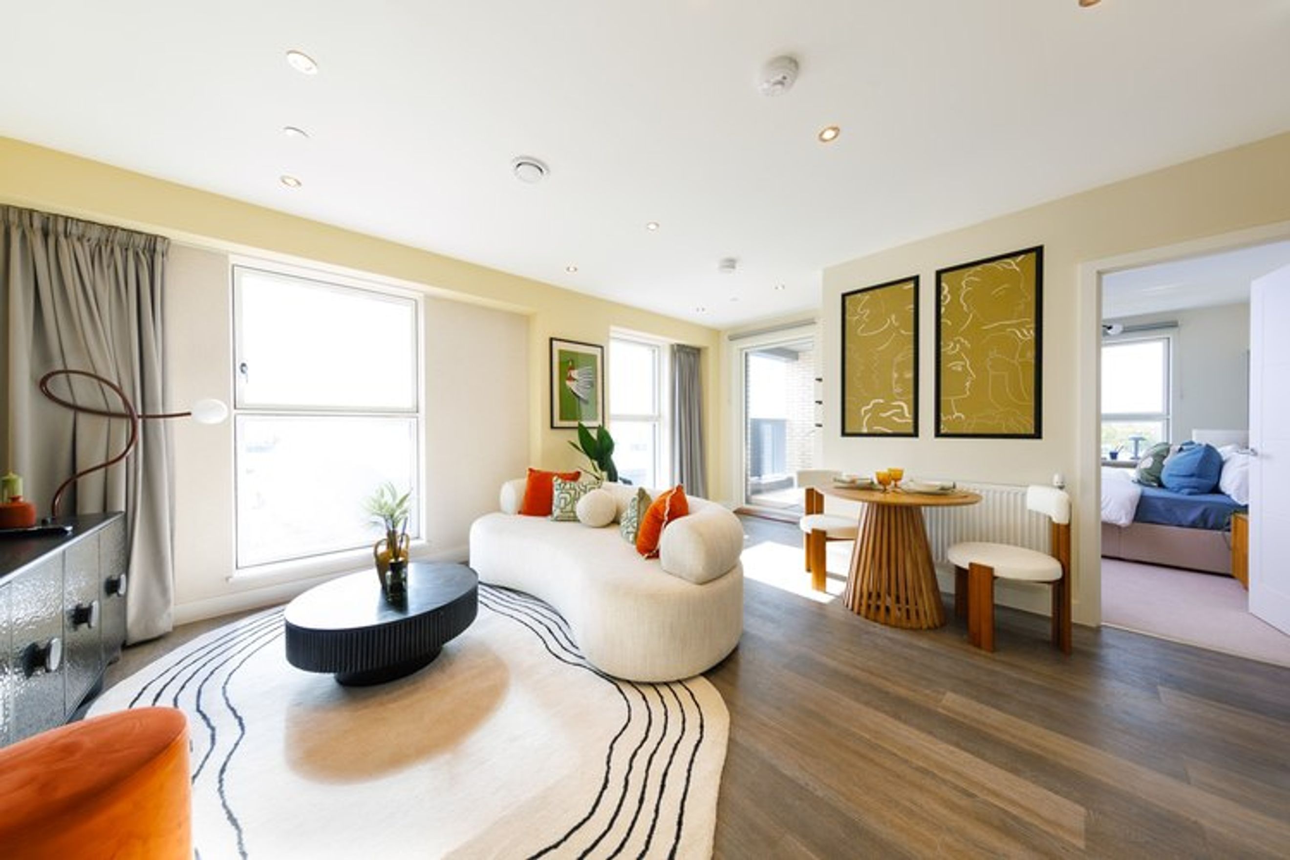 A living room with a sofa, coffee table, and dining area.