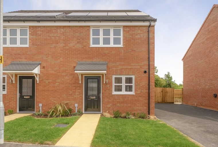 A brick-built semi-detached house with two front doors and multiple windows.
