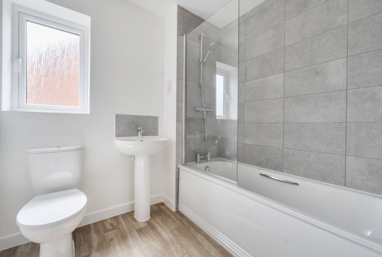A bathroom with a toilet, sink, and bathtub.