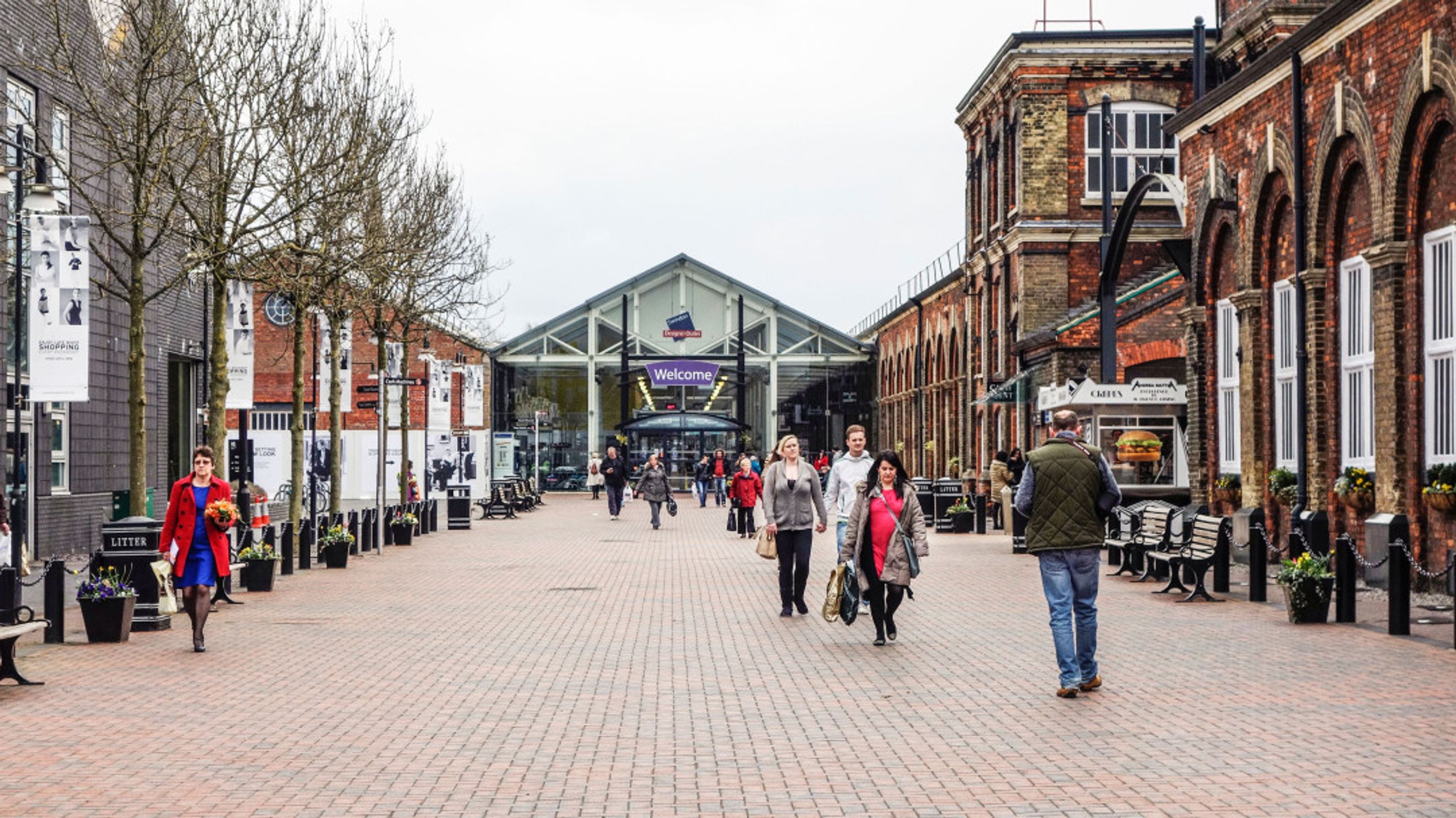 A pedestrian walkway lined with shops and people.