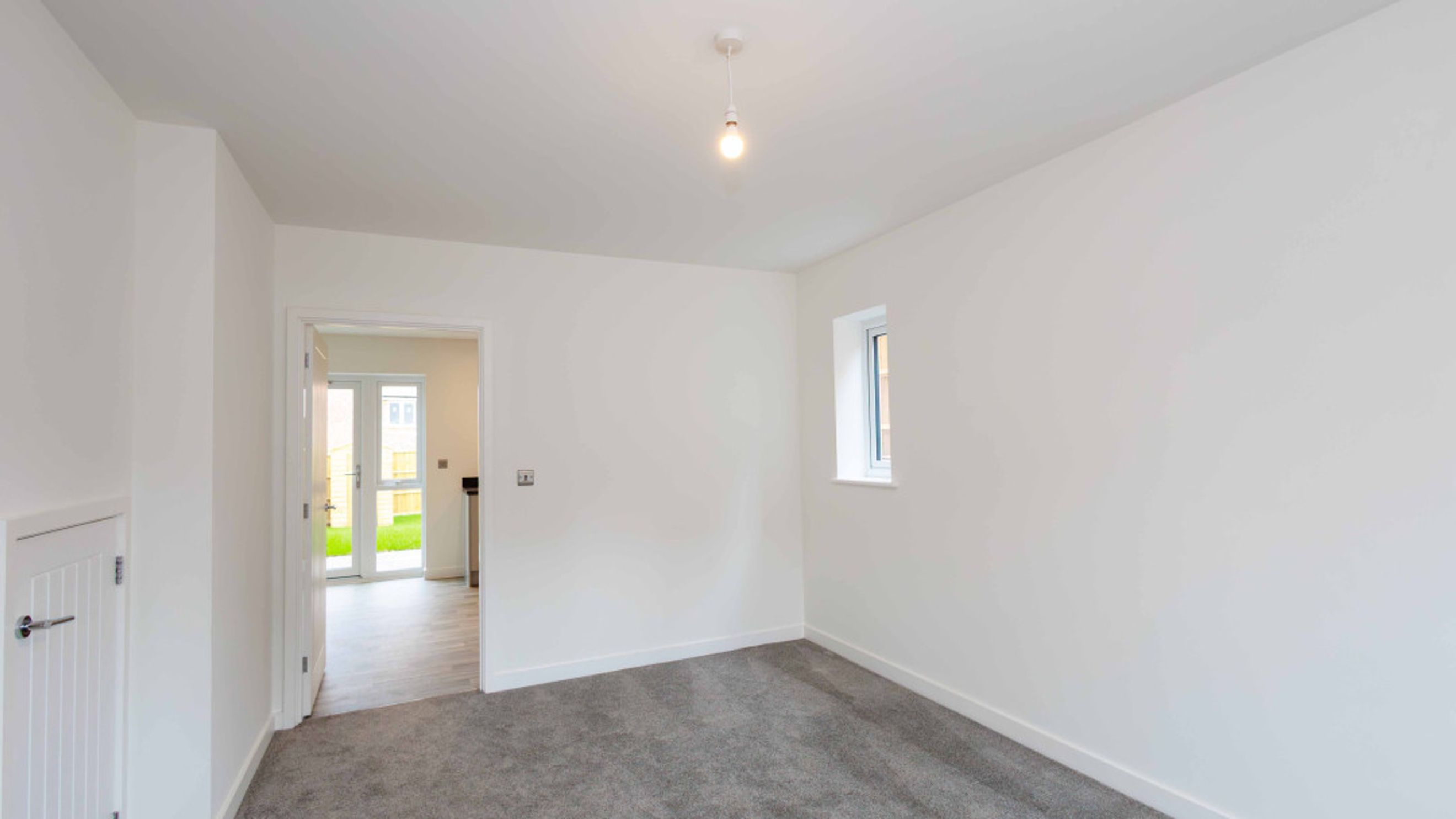 A room with a doorway leading to a garden and a small window.
