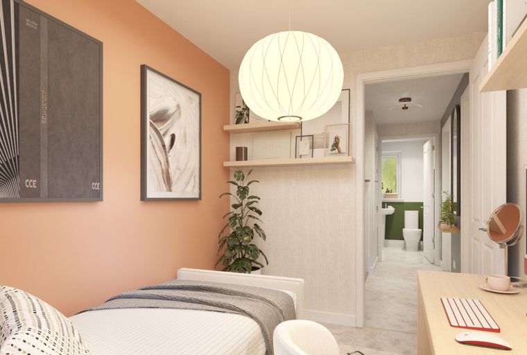 A bedroom with a bed, desk, and a view into a bathroom.