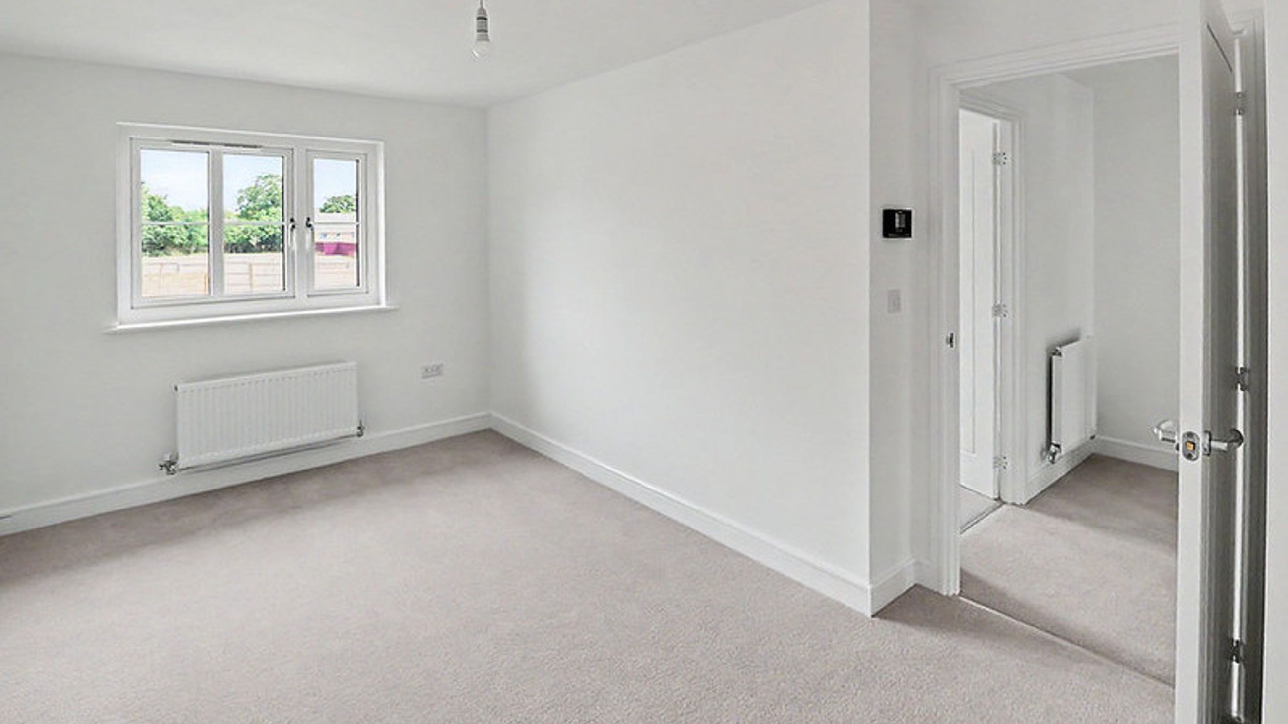 A bedroom with a window and a radiator.