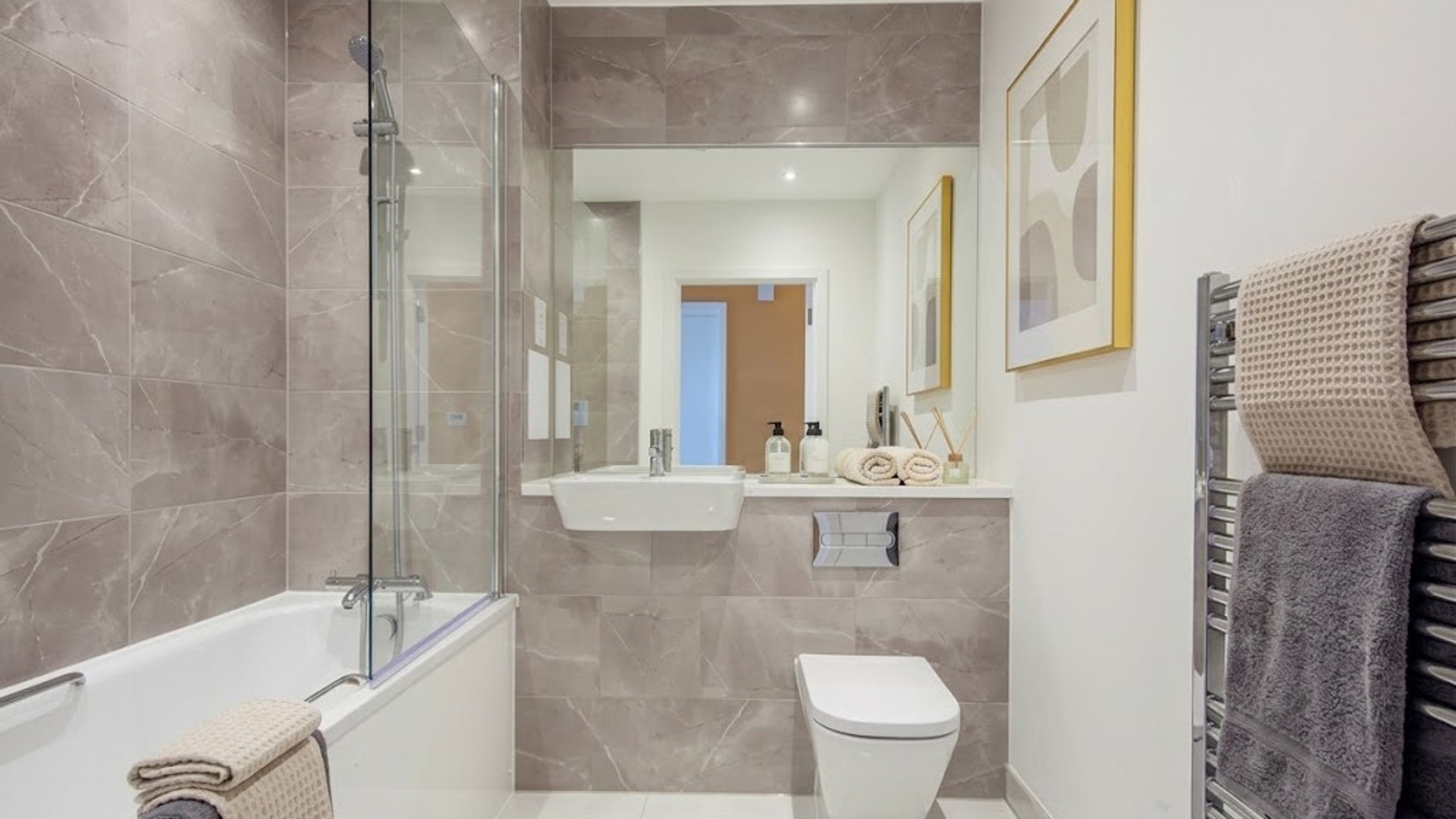 A bathroom with a bathtub, toilet, sink, and a mirror.