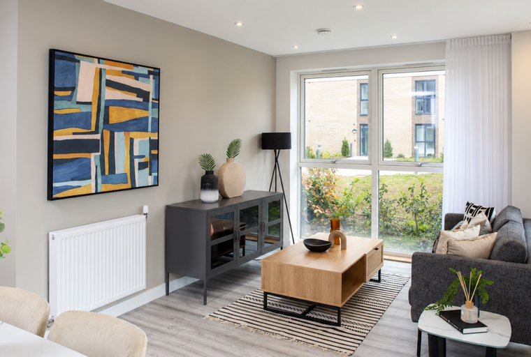 A living room with a sofa, coffee table, and artwork.