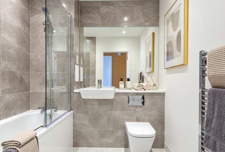 A bathroom with a bathtub, sink, toilet, and a mirror.