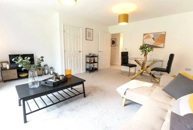 A living and dining room with a sofa, coffee table, dining table, and chairs.
