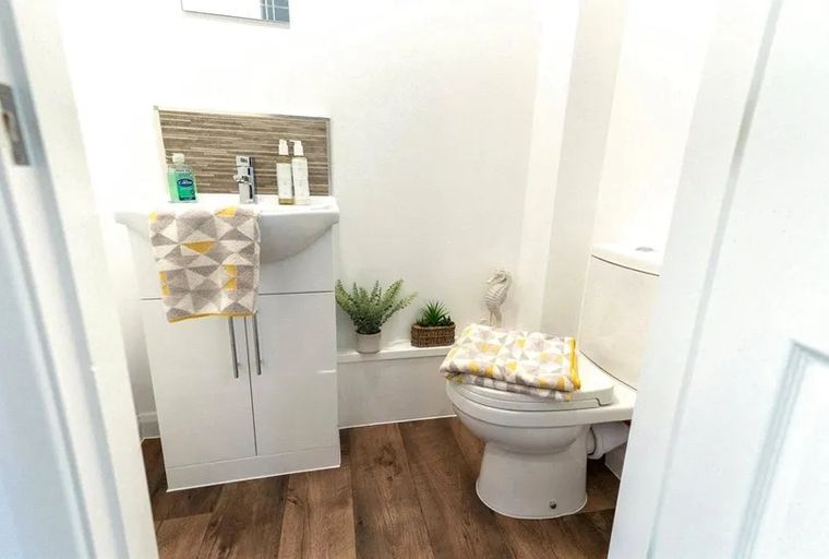 A bathroom with a sink, toilet, and towels.