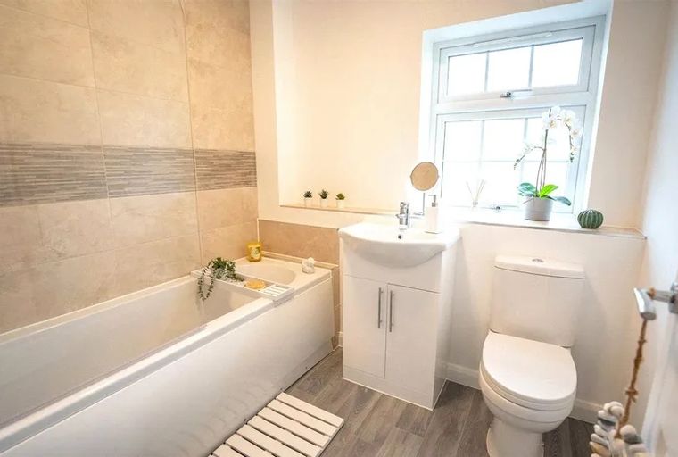 A bathroom with a bathtub, sink, and toilet.