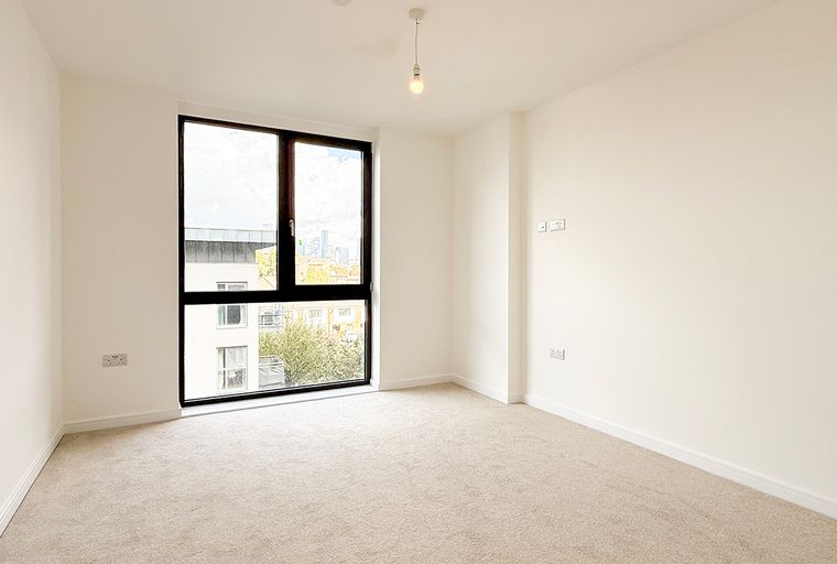 A room with a large window and carpeted floor.