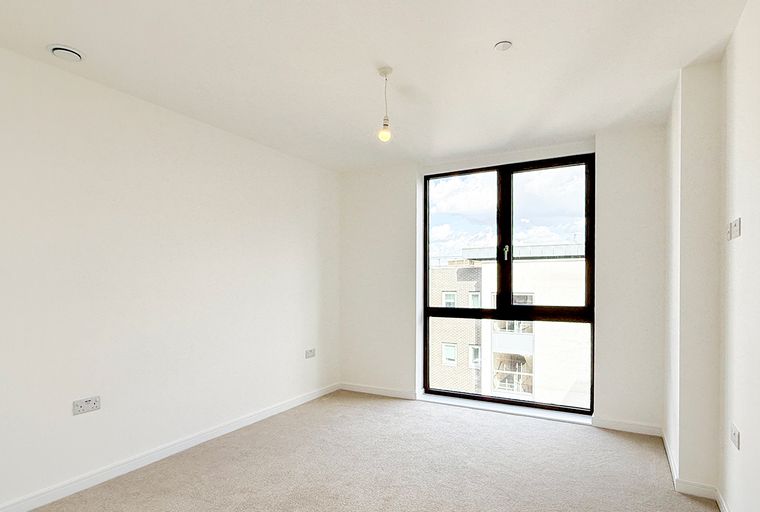 A room with a large window and a carpet.