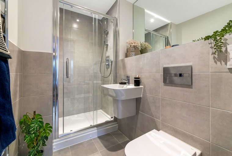 A bathroom with a shower, sink, and toilet.