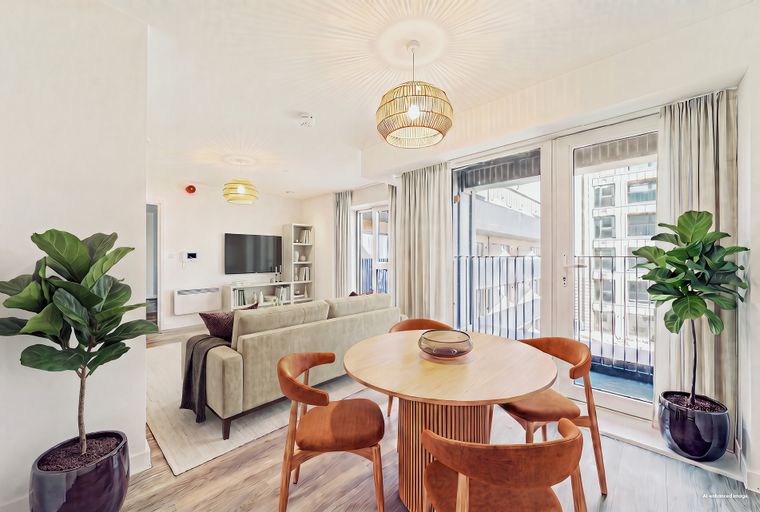 A dining area and living room with a round table, chairs, a sofa, and a television.