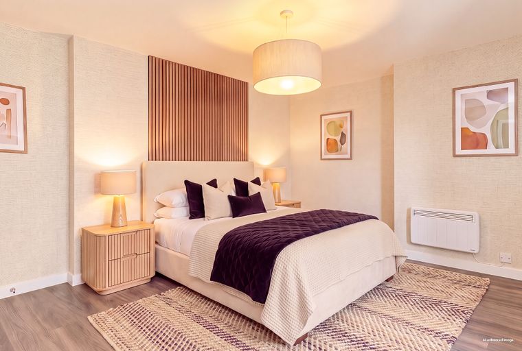 A bedroom with a bed, bedside tables, lamps, and wall art.