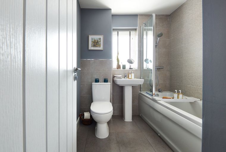 A bathroom with a toilet, sink, and bathtub.