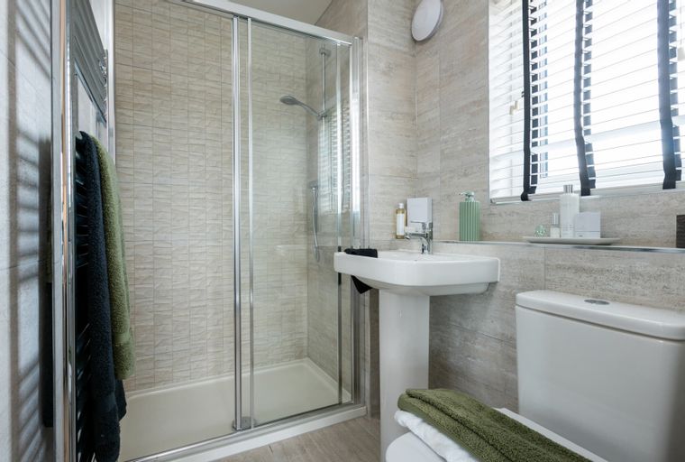 A bathroom with a shower, sink, and toilet.