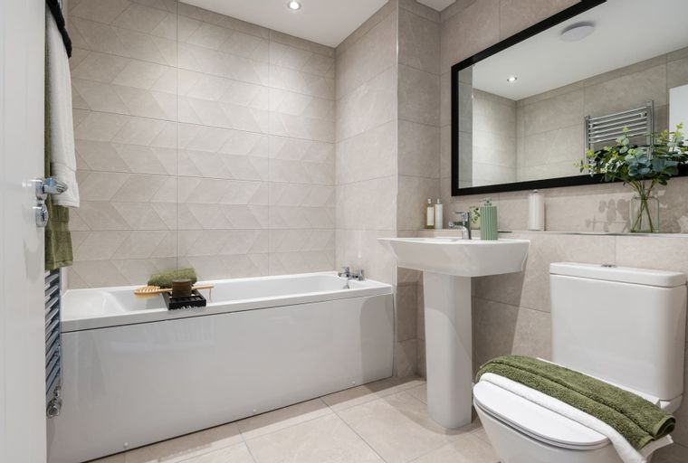 A bathroom with a bathtub, sink, toilet, and mirror.