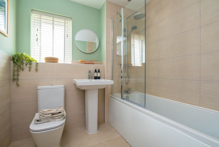 A bathroom with a toilet, sink, and bathtub with a shower.