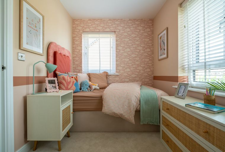 A bedroom with a bed, nightstand, and dresser.