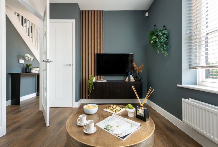 A living room with a TV, coffee table, and a doorway.