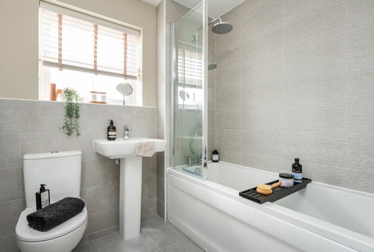 A bathroom with a toilet, sink, and bathtub with a shower.