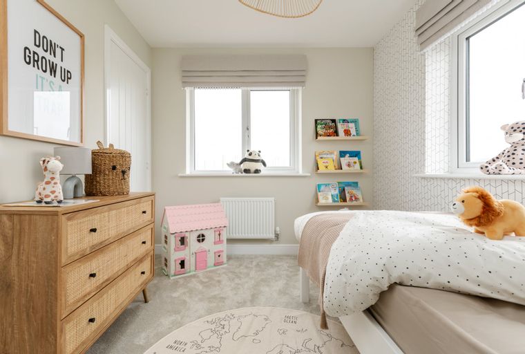 A child's bedroom with a dresser, bed, and stuffed animals.