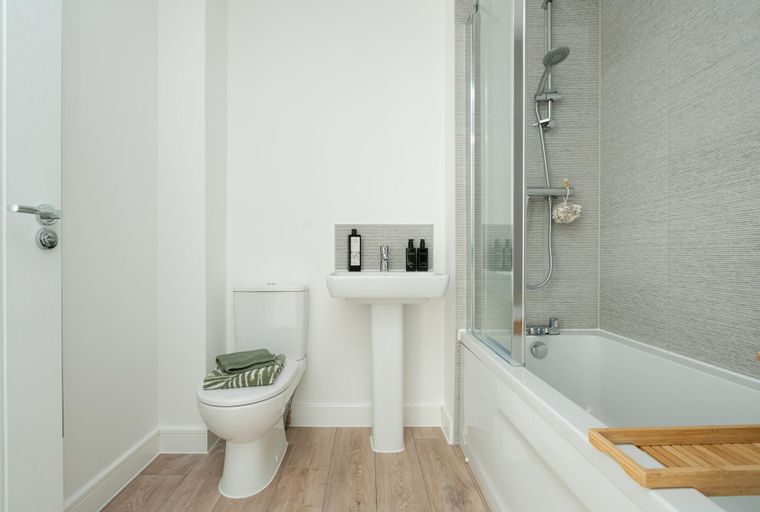 A bathroom with a toilet, sink, and bathtub.