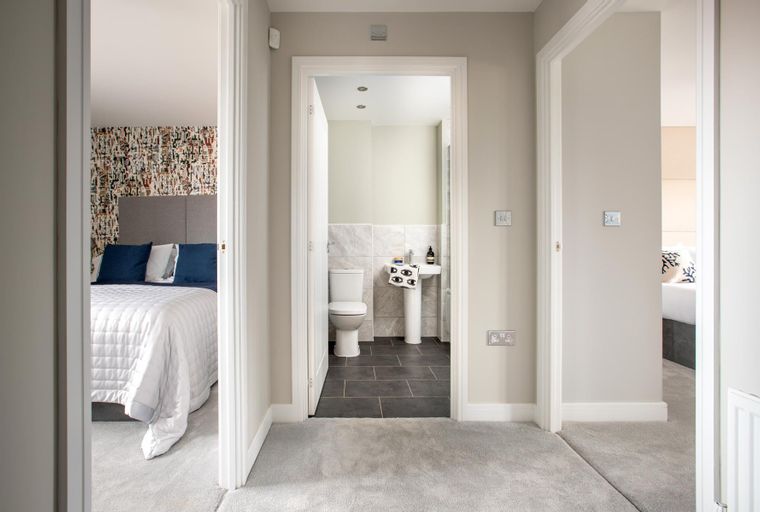 A hallway with doorways leading to a bedroom and a bathroom.