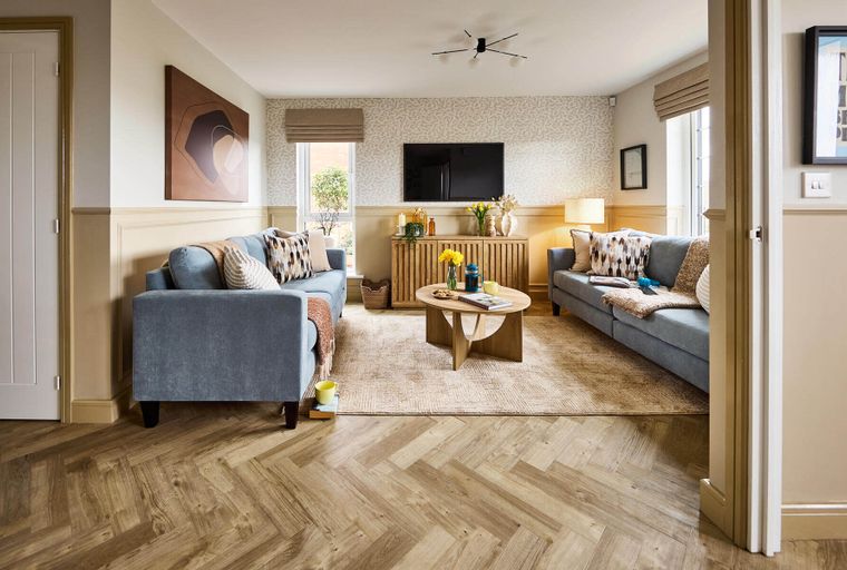A living room with two blue sofas, a coffee table, and a television.