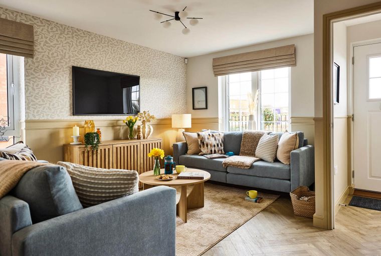 A living room with a grey sofa, coffee table, and television.
