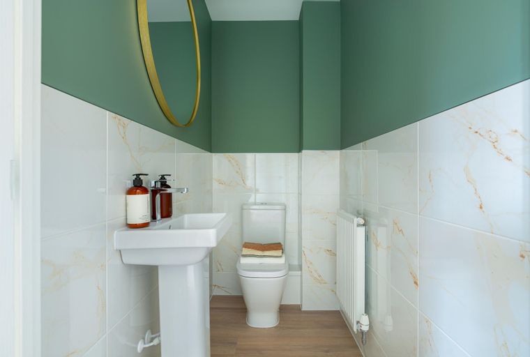 A bathroom with a sink, toilet, and radiator.