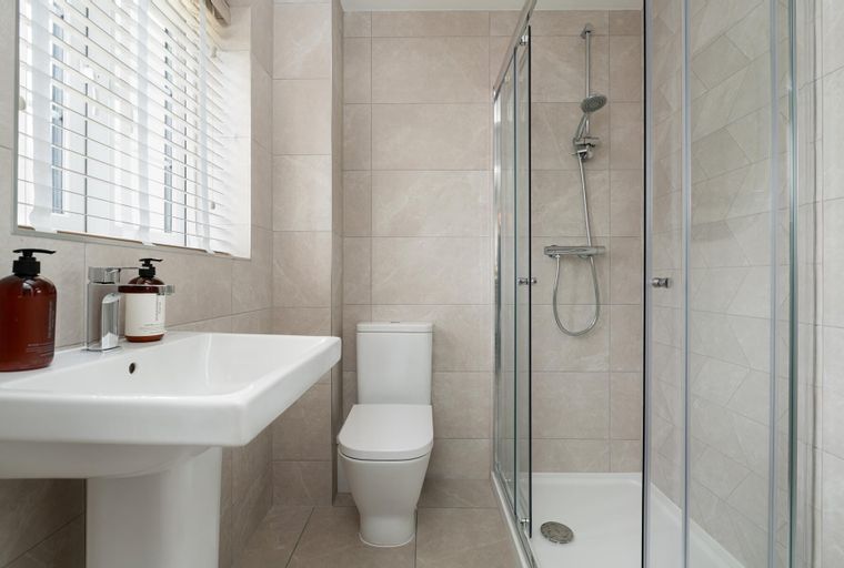 A bathroom with a sink, toilet, and shower.