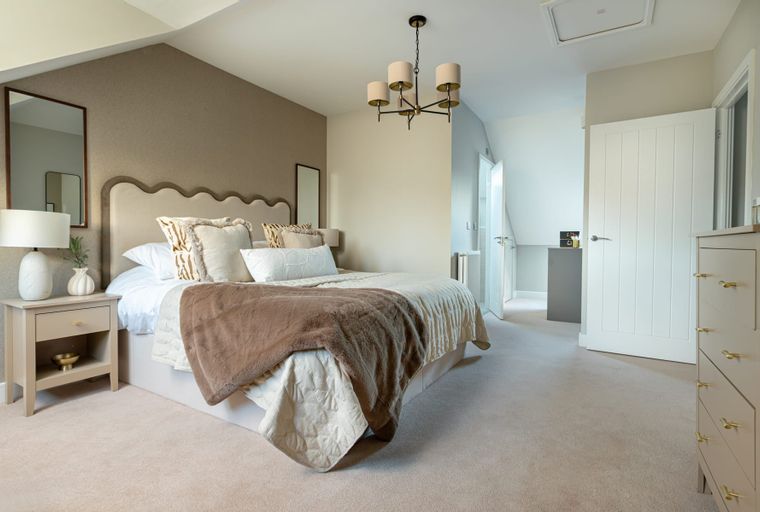 A bedroom with a bed, bedside table, and a dresser.