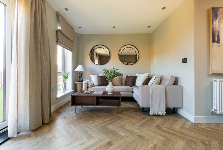 A living room with a sectional sofa, coffee table, and mirrors.