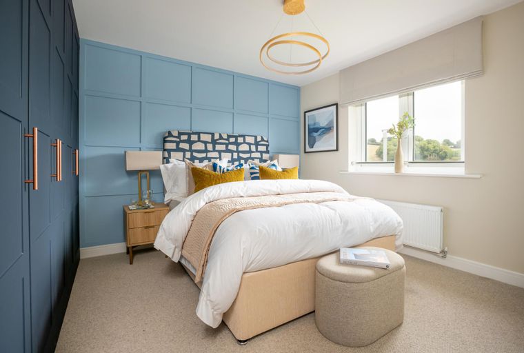 A bedroom with a bed, bedside table, and a window.