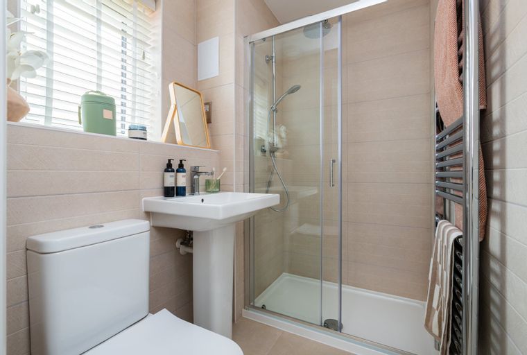 A bathroom with a toilet, sink, and a glass-enclosed shower.