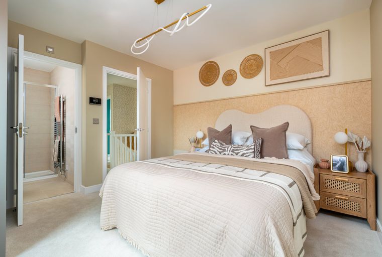 A bedroom with a bed, bedside table, and an en-suite bathroom.