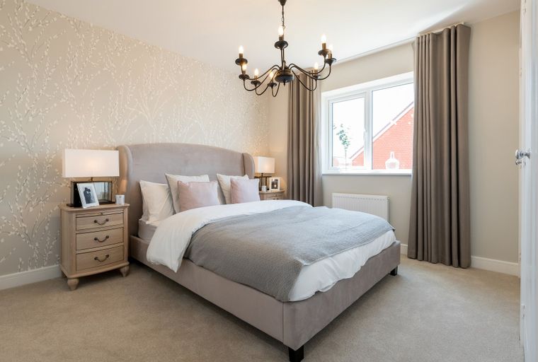 A bedroom with a bed, nightstands, and a window.