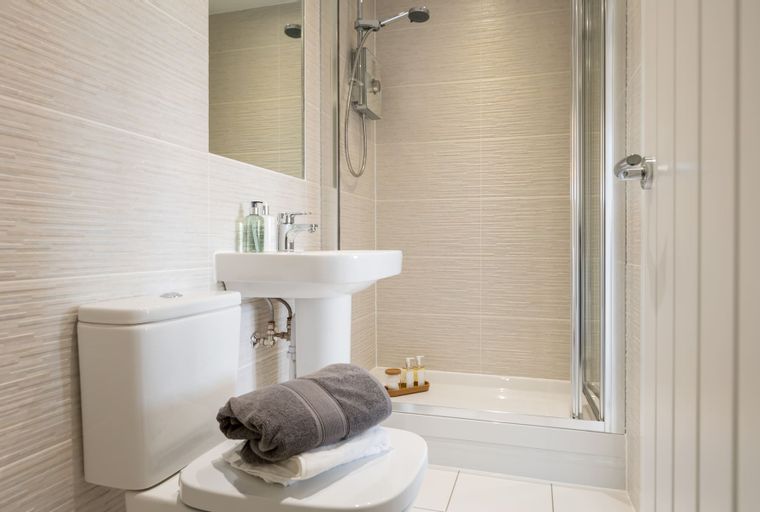 A bathroom with a toilet, sink, and shower.