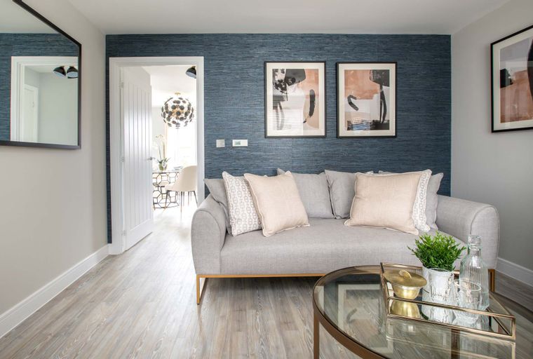 A living room with a sofa, coffee table, and a doorway leading to a dining area.