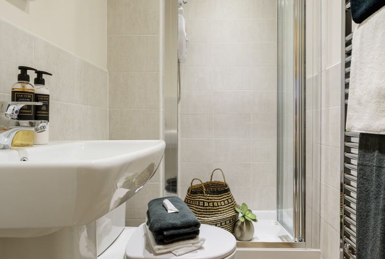 A bathroom with a sink, toilet, and shower.