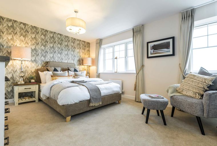 A bedroom with a bed, bedside tables, lamps, and a window.