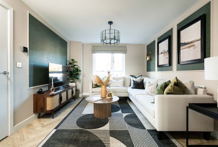 A living room with a sectional sofa, coffee table, television, and a large rug.