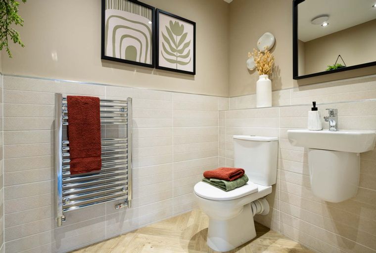A bathroom with a toilet, sink, and towel warmer.