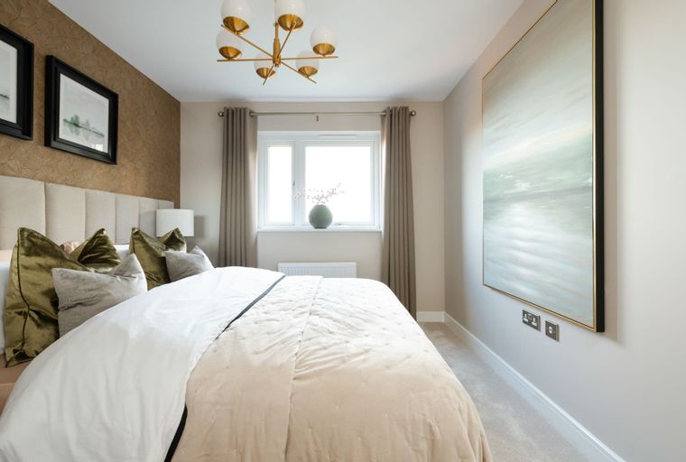 A bedroom with a bed, pillows, a chandelier, and a window.