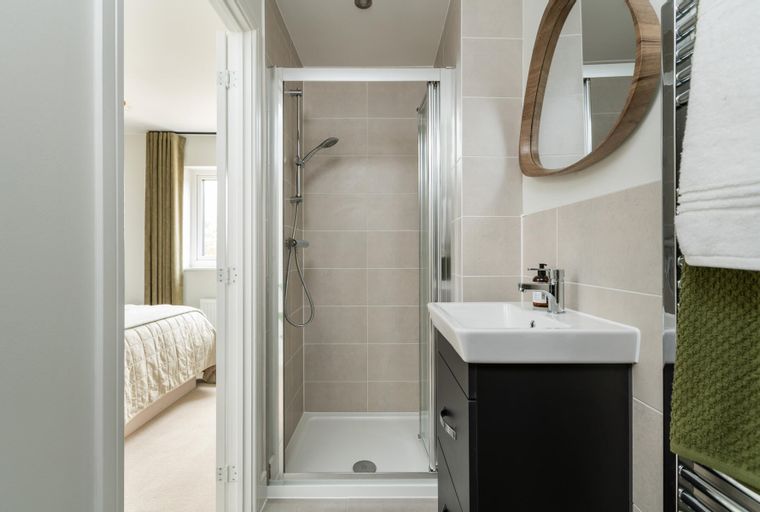 A bathroom with a shower, a sink, and a mirror.