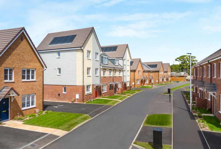 A street lined with new houses with solar panels on the roofs.