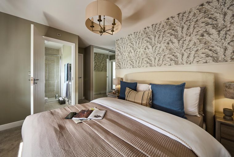 A bedroom with a bed, pillows, and an open door leading to a bathroom.