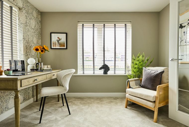 A home office with a desk, chair, and a window with blinds.